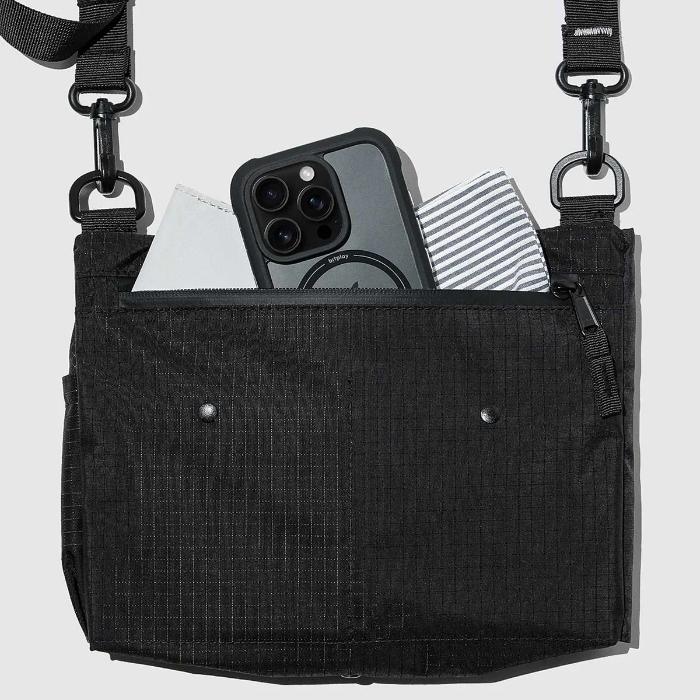 Black Bitplay Black Series Sacoche 2L Crossbody Bag/Chest Bag with a phone and papers inside on a light gray background