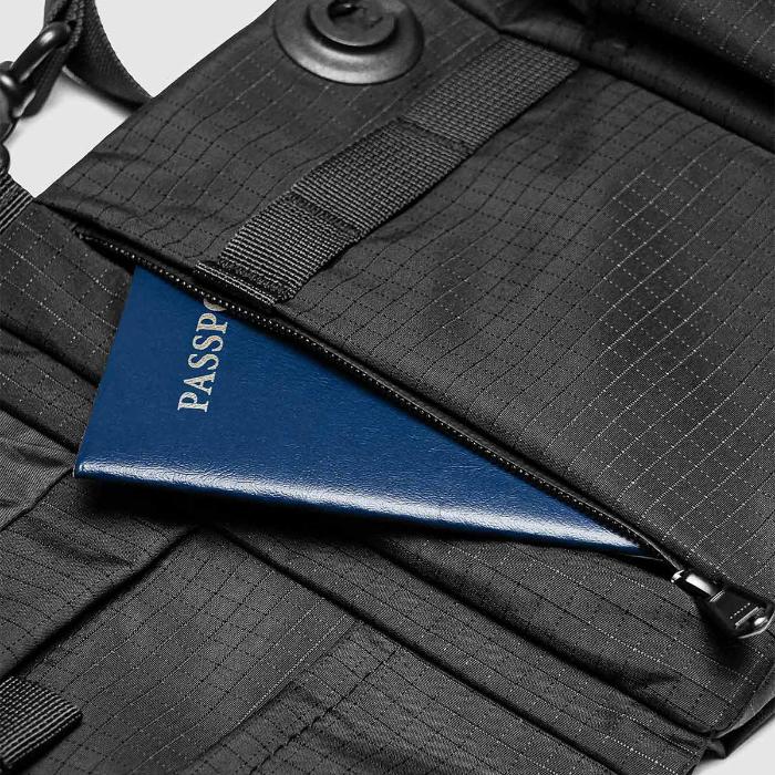 Black Bitplay Black Series Sacoche 2L Crossbody Bag/Chest Bag with a blue passport inside