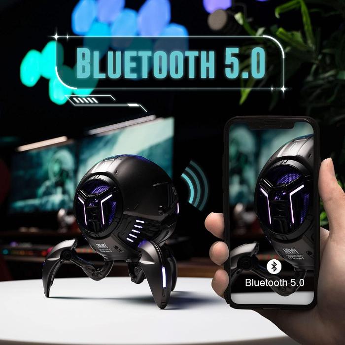 Matte Black GravaStar G1 Pro Mars Pro Wireless Bluetooth 5.0 Speaker with Bluetooth 5.0 feature held by a hand, with a smartphone displaying the same feature.