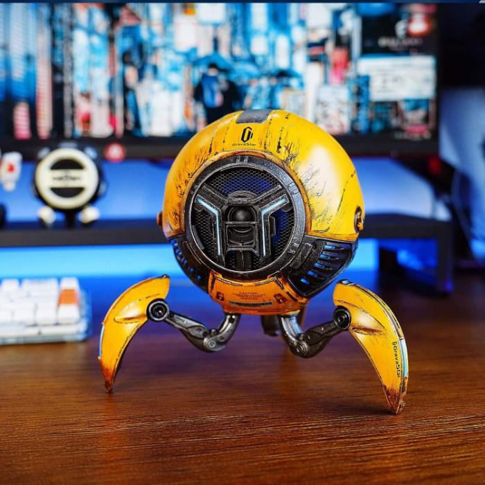 Yellow GravaStar G1 Pro Mars Pro Wireless Bluetooth 5.0 Speaker (War Damaged Edition) on a wooden surface with a blurred background