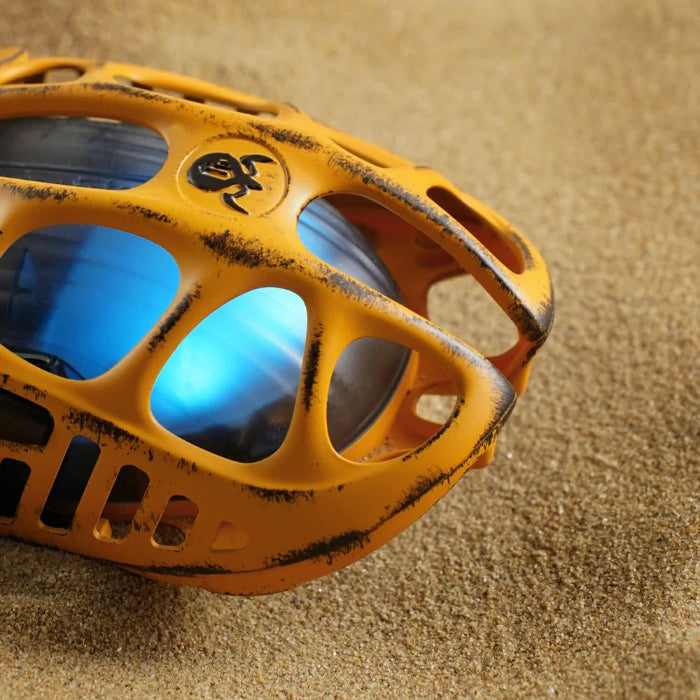 Yellow Gravastar Mercury X Wireless Gaming Mouse on a sandy background