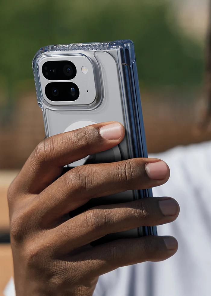 Hand holding a smartphone with a Transparent ITSKINS Hybrid R Clear Hinge Magnetic Case for Google Pixel 10 Pro Fold (2025), blurred natural background