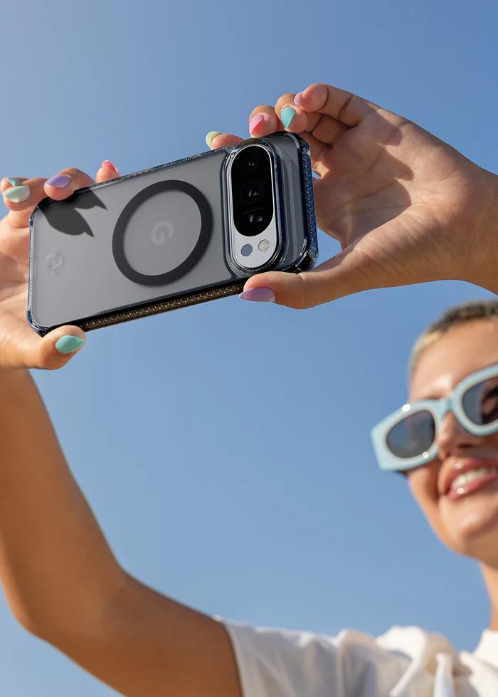 Person holding a smartphone with a Smoke ITSKINS Hybrid R Vapor Magnetic Case for Google Pixel 10 Pro XL (2025) against a blue sky